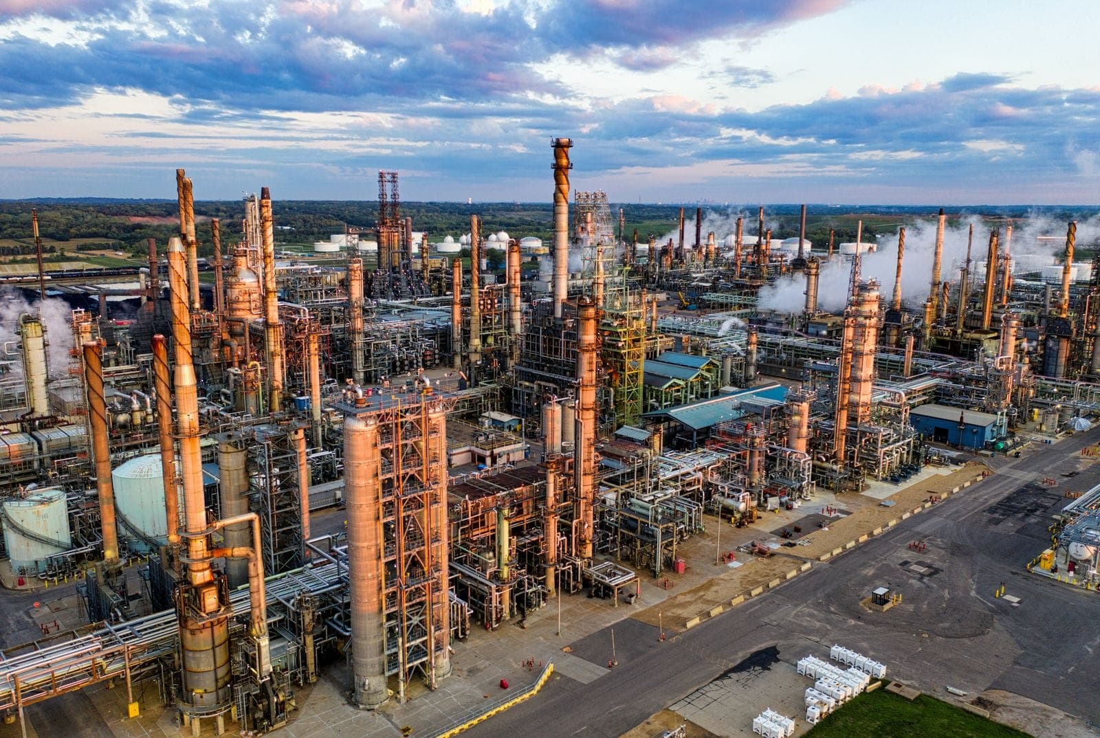 Oil refinery towers and piping at dusk